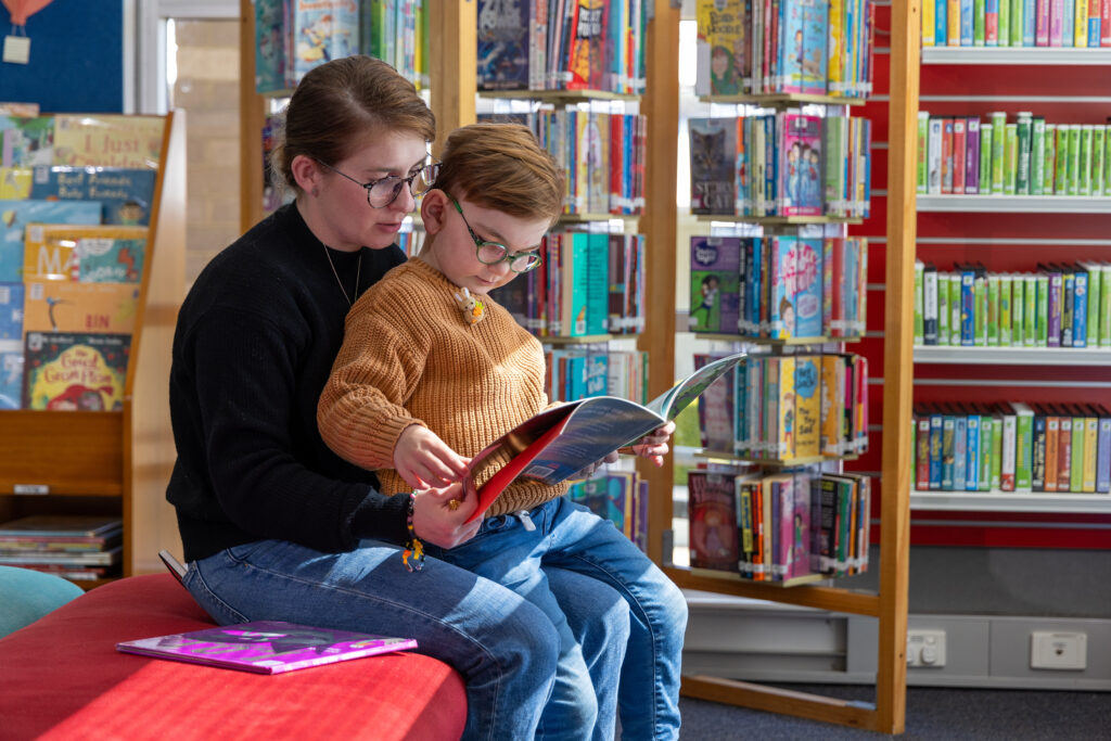 Mum with son on her lap reading at THE BOWRAL CITY LIBRARY
