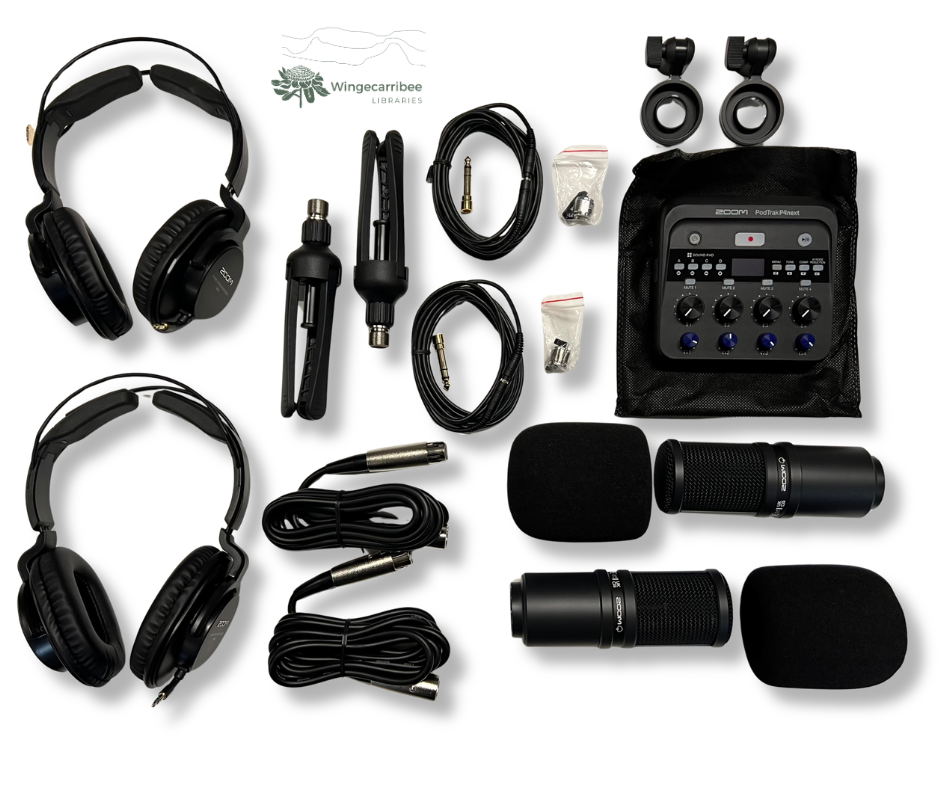 Podcasting kit sits on a table with all contents laid out. There are two headphones with cords, two microphones with mic tripod stands, and the podcast deck.