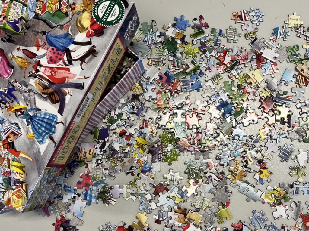 Puzzle on a table with some pieces laid out on the table and the box in the top let corner.